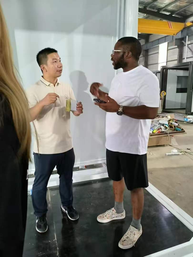 Feeker representative explaining prefab house details to an international buyer inside the factory